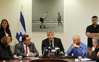 Yair Lapid, center, at a meeting of his Yesh Atid Knesset faction. (photo credit: Miriam Alster/Flash90)