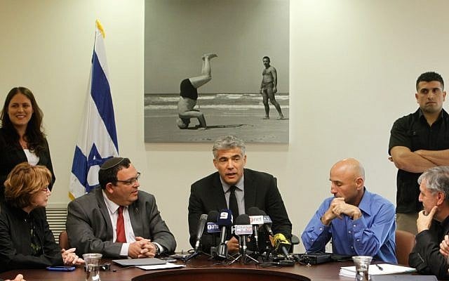 Yair Lapid, center, at a meeting of his Yesh Atid Knesset faction. (photo credit: Miriam Alster/Flash90) Yair Lapid, center, at a meeting of his Yesh Atid Knesset faction. (photo credit: Miriam Alster/Flash90)