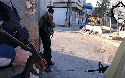 Syrian rebels taking cover during fighting against government forces. (photo credit: AP/Local Council of Barzeh)