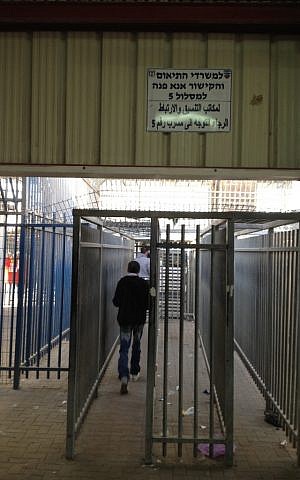 A Palestinian man walks through the Qalandiya checkpoint, April 30 (photo credit: Elhanan Miller/Times of Israel)