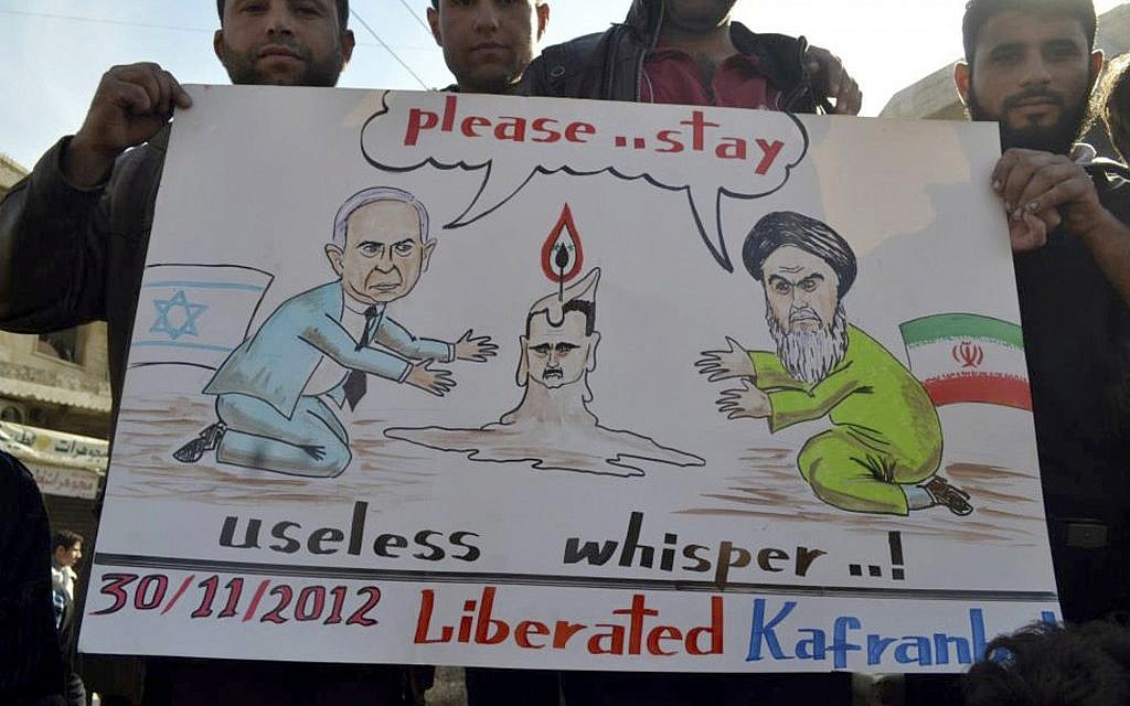 Anti-Assad protesters hold up a caricature placard representing Iranian supreme leader Ayatollah Ali Khamenei, right, and Israeli Prime Minister Benjamin Netanyahu, left, during a demonstration at Kfar Nebel near Idlib, Friday, Nov. 30, 2012 (photo credit: AP/ENN) Anti-Assad protesters hold up a caricature placard representing Iranian supreme leader Ayatollah Ali Khamenei, right, and Israeli Prime Minister Benjamin Netanyahu, left, during a demonstration at Kfar Nebel near Idlib, Friday, Nov. 30, 2012 (photo credit: AP/ENN)