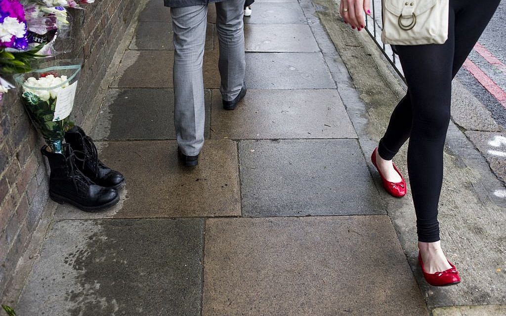 People walk by military boots that were laid in tribute outside the Woolwich Barracks, in London, Friday, May 24, 2013, in response to the bloody attack on Wednesday when a British soldier was killed in the nearby street (photo credit: AP/Bogdan Maran) People walk by military boots that were laid in tribute outside the Woolwich Barracks, in London, Friday, May 24, 2013, in response to the bloody attack on Wednesday when a British soldier was killed in the nearby street (photo credit: AP/Bogdan Maran)