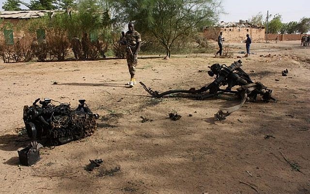 Nigerien soldiers walk near debris after suicide bombers blew themselves up inside a military barracks, in Agadez, northern Niger on May 23. (photo credit: AP)