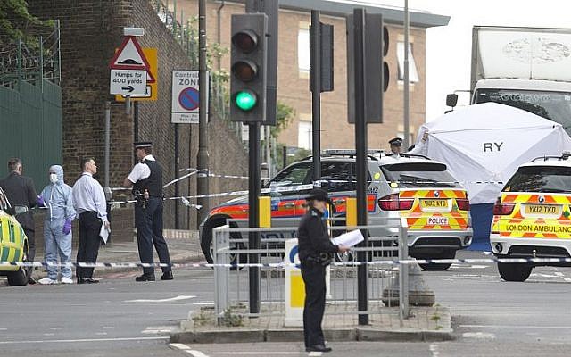 Police and forensic officers near the scene of a terror attack near Woolwich barracks in London, May 22, 2013. (AP/Alastair Grant) Police and forensic officers near the scene of a terror attack near Woolwich barracks in London, May 22, 2013. (AP/Alastair Grant)