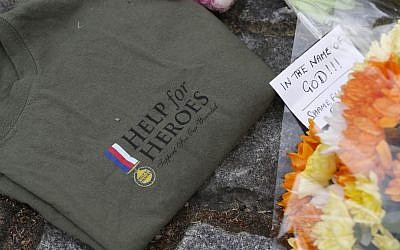 A 'Help for Heroes' T-shirt and floral tributes in memory of the victim lay on the pavement outside the Royal Artillery Barracks near the scene of a terror attack in Woolwich, southeast London, Thursday, May 23, 2013 (photo credit: Sang Tan/AP)