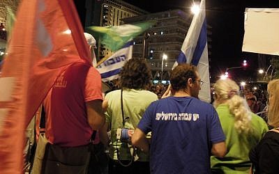 Demonstrators wave opposition party flags at a protest against budget cuts in Jerusalem. (photo credit: Yifa Yaakov/The Times of Israel) Demonstrators wave opposition party flags at a protest against budget cuts in Jerusalem. (photo credit: Yifa Yaakov/The Times of Israel)
