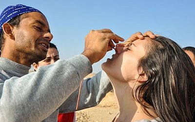 Swadesh Sharma helps Samantha place the small tube through her nostril. The kriya cleans out excess build up that accumulates in the nasal passage. (photo credit: Michal Shmulovich)