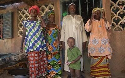 Dougoutigo Fadiga, president of Bani Israel, outside his Senegal home with his three wives and one of his sons, May 2013. (photo credit: Cnaan Liphshiz/JTA)