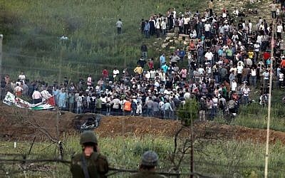 Demonstrators gather along Syria's border with Israel before trying to cut through a line of barbed wire and head into the Israeli-annexed Golan Heights, as seen from the Druze village of Majdal Shams, on June 5, 2011 (Flash90)