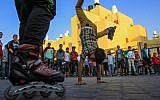 Time will tell if this is manly enough behavior. A Palestinian youth with skates on his feet stands on his hands in the southern Gaza town of Rafah during a rally for solidarity with Palestinian prisoners in April 2013. (photo credit: Abed Rahim Khatib/Flash90).