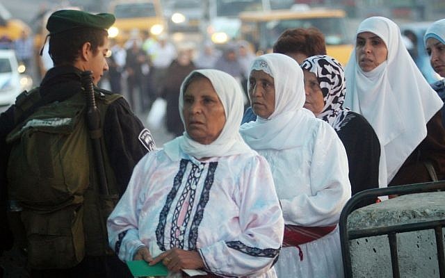 Israeli border police officers check documents of Palestinian women who wait to cross the Qalandia checkpoint on the outskirts of the West Bank city of Ramallah. photo credit: (Issam Rimawi/Flash90) 