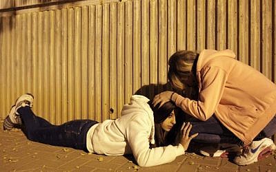 Young Israeli women take cover as a siren sounds warning of incoming rockets fired from Gaza, November 21, 2012. (photo credit: Edi Israel/FLASH90)
