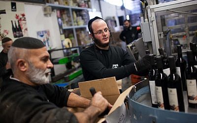 Workers at the Arza winery in the Mishor Adumim industrial area in the West Bank. (photo credit:  Yonatan Sindel/Flash90)