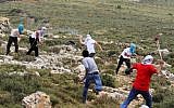 Illustrative photo: Masked Jewish settlers, background, and Palestinians, foreground, hurl stones during clashes in the West Bank, Friday, May 3, 2013. (Issam Rimawi/Flash90)