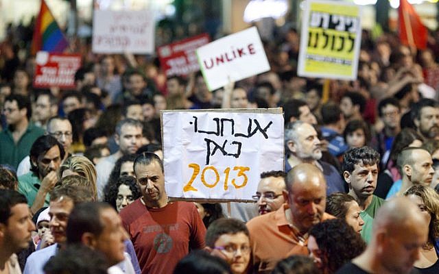 Israelis hold up signs as they take part in a protest march against Finance Minister Yair Lapid's proposed budget cuts and tax hikes, in Tel Aviv on Saturday, May 11, 2013. (photo credit: Flash90) Israelis hold up signs as they take part in a protest march against Finance Minister Yair Lapid's proposed budget cuts and tax hikes, in Tel Aviv on Saturday, May 11, 2013. (photo credit: Flash90)