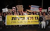 Protesters hold up signs and chant slogans as they gather outside the house of businessman Yitzhak Tshuva, in Ramat Poleg, Netanya, in a May 18 protest calling for a change in the goverment's gas export policy (Photo credit: Gili Yaari/Flash 90)