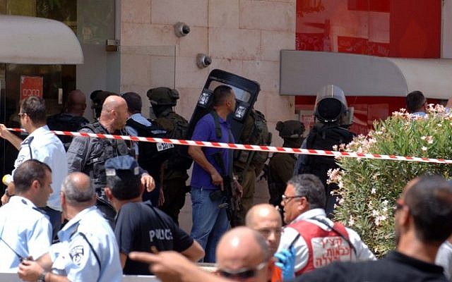 The crime scene outside the Bank Hapoalim in Beersheba where four people were killed by a local gunman on May 20, 2013. (photo credit: Dudu Greenspan/Flash90) The crime scene outside the Bank Hapoalim in Beersheba where four people were killed by a local gunman on May 20, 2013. (photo credit: Dudu Greenspan/Flash90)