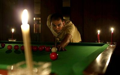 An Egyptian man plays snooker by candlelight at a club in the Mohandessin district, in Giza, Egypt, on Saturday, May 25, 2013. (photo credit: AP Photo/Hassan Ammar)