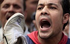 An Egyptian man chants anti-Israeli slogans during a Muslim Brotherhood-staged anti-Israel rally in Cairo on Friday. Meanwhile, a youth activist was detained Friday for 'incitement' a few days after he expressed criticism of Morsi's party via his movement's website (photo credit: Khalil Hamra/AP)