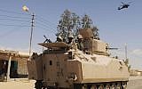 Egyptian army soldiers patrol in an armored vehicle, backed by a helicopter gunship, during a sweep through villages in the northern Sinai Peninsula, Egypt, in May 2013. (AP)