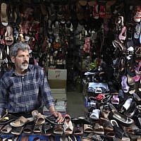 An Iranian shoe seller stands in his shop in the old bazaar of the eastern city of Birjand, Iran. When struggling families in the eastern Iranian city of Birjand take measure of Mahmoud Ahmadinejad's presidency in its waning weeks, it's not about his browbeating oratory against the West or his battles with Iran's ruling clerics. Instead, it's the rows of simple two-story homes on the city's outskirts that sharply improved their lives. (photo credit: AP/Vahid Salemi)