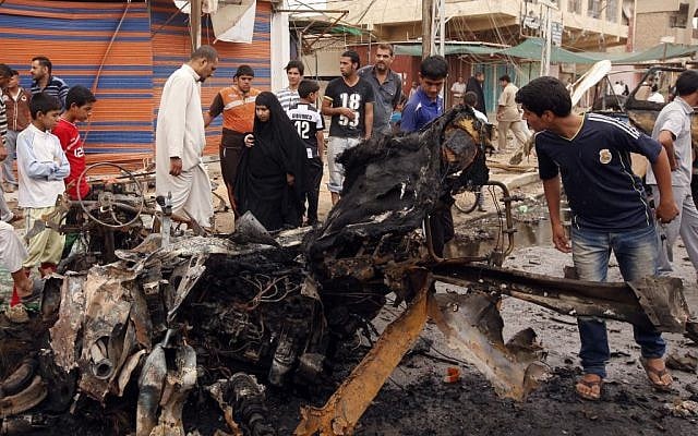 Civilians inspect the scene of a car bomb attack in the Kamaliyah neighborhood, a predominantly Shiite area of eastern Baghdad, Iraq, Monday, May 20, 2013 (photo credit: AP/Hadi Mizban) Civilians inspect the scene of a car bomb attack in the Kamaliyah neighborhood, a predominantly Shiite area of eastern Baghdad, Iraq, Monday, May 20, 2013 (photo credit: AP/Hadi Mizban)