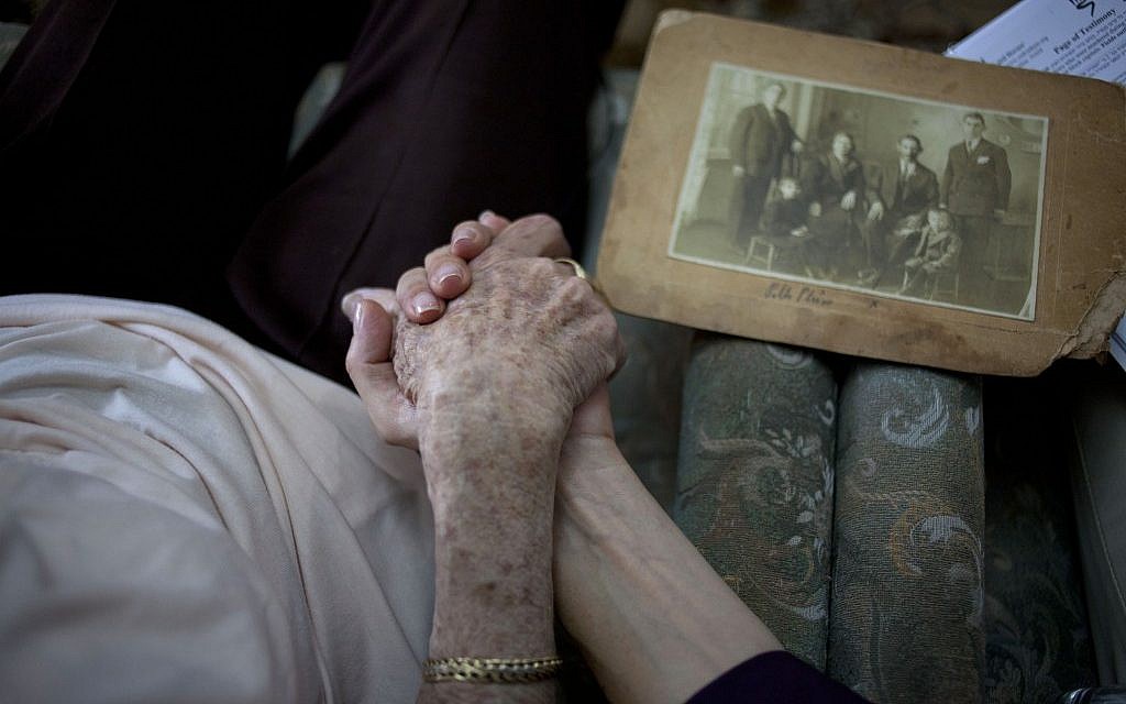 Holocaust survivor Rivka Fringeru, 82, left, holds hand with Cynthia Wroclawski, director of the Yad Vashem names collection project, Sunday, May 5, 2013 (photo credit: AP/Ariel Schalit) Holocaust survivor Rivka Fringeru, 82, left, holds hand with Cynthia Wroclawski, director of the Yad Vashem names collection project, Sunday, May 5, 2013 (photo credit: AP/Ariel Schalit)