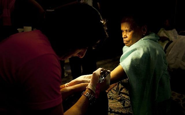 Wassim Razzouk tattoos an Ethiopian Christian Orthodox pilgrim in a hotel in Jerusalem. The Razzouk family has been tattooing pilgrims with crosses and other religious symbols for hundreds of years, testament to the importance of the ancient ritual. While Catholics can get a written certificate of their pilgrimage to Jerusalem, Orthodox Christians opt for a tattoo, a permanent reminder of their visit. (photo credit: AP/Dusan Vranic)
