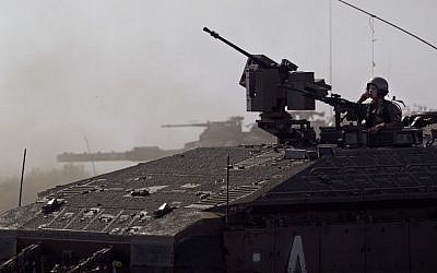 An Israeli soldier driving an armored personal carrier during a military exercise in the Golan Heights, near the border with Syria on Tuesday. (photo credit: AP/Ariel Schalit)