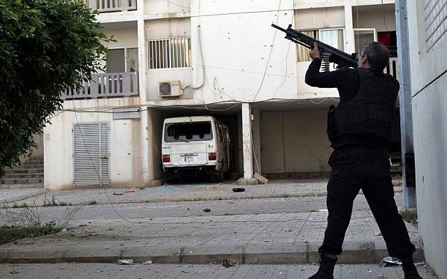 A Sunni gunman fires his machine gun during clashes that erupted between pro and anti-Syrian regime gunmen, in the northern port city of Tripoli, Lebanon, Thursday, May 23, 2013 (photo credit: AP)