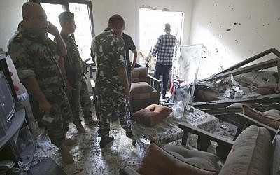 Soldiers examine a Beirut home hit by rockets, Sunday (photo credit: Hussein Malla/AP) Soldiers examine a Beirut home hit by rockets, Sunday (photo credit: Hussein Malla/AP)