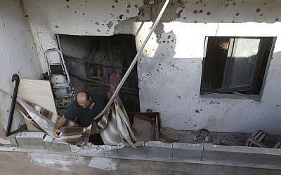 A Lebanese investigator takes pictures at a balcony where a rocket struck an apartment in a building at Chiyah district, south of Beirut, Lebanon, Sunday May 26, 2013 (photo credit: AP/Hussein Malla) A Lebanese investigator takes pictures at a balcony where a rocket struck an apartment in a building at Chiyah district, south of Beirut, Lebanon, Sunday May 26, 2013 (photo credit: AP/Hussein Malla)