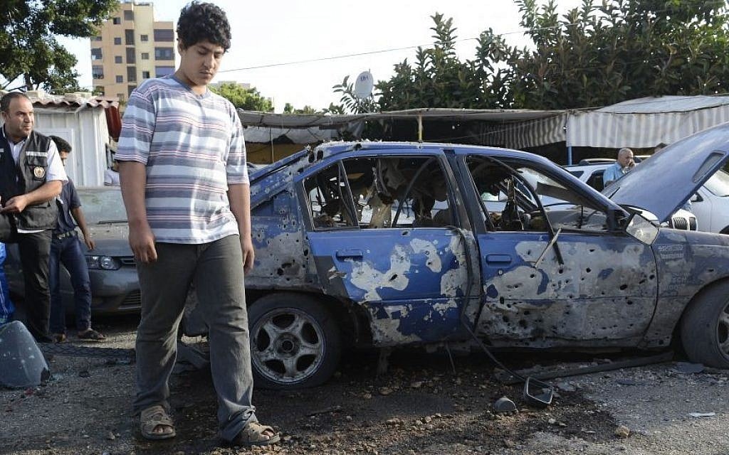 A man looks at a part of a rocket, seen on the ground, after rockets slammed into two Beirut neighborhoods that are strongholds of Lebanon's Hezbollah group, Sunday May 26, 2013. (photo credit: AP/Ahmad Omar) A man looks at a part of a rocket, seen on the ground, after rockets slammed into two Beirut neighborhoods that are strongholds of Lebanon's Hezbollah group, Sunday May 26, 2013. (photo credit: AP/Ahmad Omar)