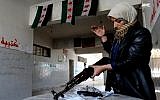 This Tuesday, May 14, 2013 citizen journalism image provided by Aleppo Media Center AMC which has been authenticated based on its contents and other AP reporting, shows the mother of a Syrian rebel cleaning a rifle, in Aleppo, Syria. Activists say Syrian rebels have detonated two car bombs outside the main prison in the northern city of Aleppo and are trying to storm the facility, where hundreds of regime opponents are believed to be held. (Photo credit: AP/Aleppo Media Center AMC)