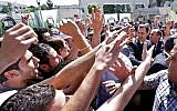 This photo released on the official Facebook page of Syrian President Bashar Assad, shows Syrian president Bashar Assad, right, surrounded by bodyguards as young people, wave at him during the inauguration ceremony on Saturday of a statue dedicated to "martyrs" from Syrian universities who died in the country's two-year-old uprising and civil war, in Damascus, Syria, Saturday, May. 4, 2013 (photo credit: AP)