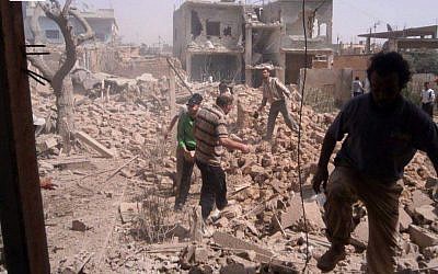 Syrians inspect the rubble of buildings damaged buildings by government airstrikes, in Qusair, Homs province, Syria, on Saturday, May 18, 2013. (photo credit: AP Photo/Qusair Lens)