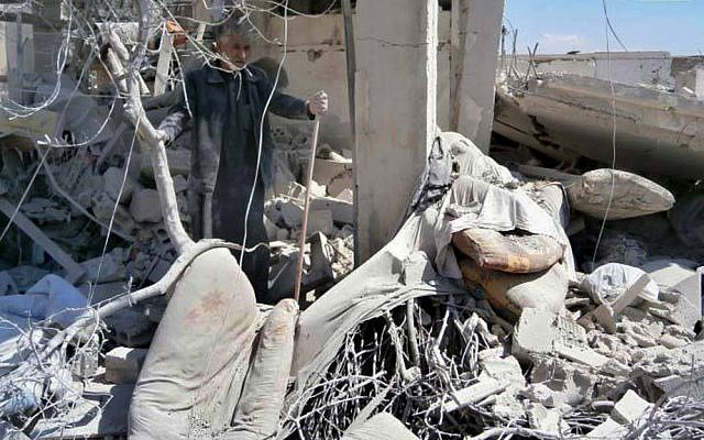 A man checks his destroyed house, damaged by a Syrian forces airstrike in the town of Qusair, near the Lebanon border, Homs province, Syria, Tuesday, May 21, 2013. (AP/Qusair Lens)