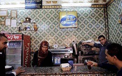 Customers are served coffee in the "Cafe de la Justice", next to the cigarette stand once run by Adel Khedri in Tunis, Tunisia. On Tuesday, March 12, 2013, Adel drank his usual espresso with milk at the cafe. Later in the morning, he made his way to Habib Bourguiba, a site of frequent demonstrations, where he set himself on fire. (AP Photo/Ons Abid)