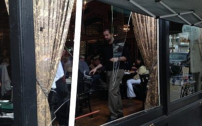A worker at Mother's Bistro & Bar in Portland deals with a broken window -- the aftermath of a busboy who went crashing through moments earlier. (photo credit: Gil Shefler/JTA) A worker at Mother's Bistro & Bar in Portland deals with a broken window -- the aftermath of a busboy who went crashing through moments earlier. (photo credit: Gil Shefler/JTA)