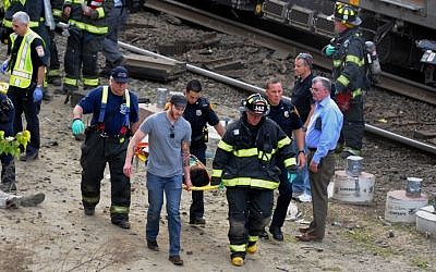 Injured passengers are transported from the scene where two Metro North commuter trains collided, Friday, May 17, 2013 near Fairfield, Conn. (Photo credit: AP/The Connecticut Post, Christian Abraham)