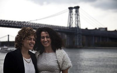 Tzila Levy, left, and Adi Lavy, married on New York City's Williamsburg Bridge, seen in the background, Oct. 27, 2012. (photo credit: Courtesy Immigration Equality/JTA)