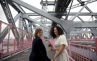 Tzila Levy, left, and Adi Lavy, standing on the Williamsburg Bridge in New York City, where they were married, Oct. 27, 2012. (photo credit: Courtesy Immigration Equality/JTA)