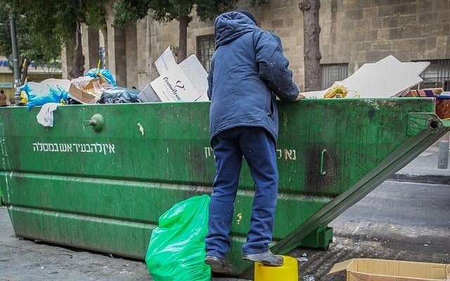 A man searches the trash in a garbage container in the center of Jerusalem. (illustrative photo by Nati Shohat/Flash90) A man searches the trash in a garbage container in the center of Jerusalem. (illustrative photo by Nati Shohat/Flash90)