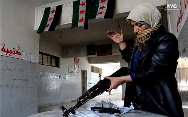 The mother of a Syrian rebel cleaning a rifle, Tuesday, May 14, 2013 (AP Photo/Aleppo Media Center AMC)