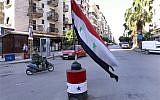 A Lebanese army soldier passes in front of Syrian flag, in the predominantly Alawite neighborhood of Jabal Mohsen in the northern port city of Tripoli, Lebanon, Tuesday, April 30, 2013. (photo credit: AP/Bilal Hussein)