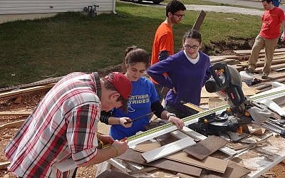 Students from the Hillels at University of Pittsburgh and Syracuse University measuring, cutting and installing trimming in Joplin, MO (photo credit: Courtesy of JDRC)