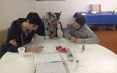 Avi Rothberg, Shanjida Chowdhury, and Zachary Schwarzbaum from Bridges New York University engaged in interfaith text study after a long day of work.  (photo credit: Courtesy of JDRC)