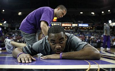 Sacramento Kings guard Marcus Thornton is seen getting stretched out from Kings strength and conditioning coach Daniel Shapiro before their NBA basketball game against the Orlando Magic in Sacramento, Calif, Jan. 8, 2012. (photo credit: AP Photo/Rich Pedroncelli)