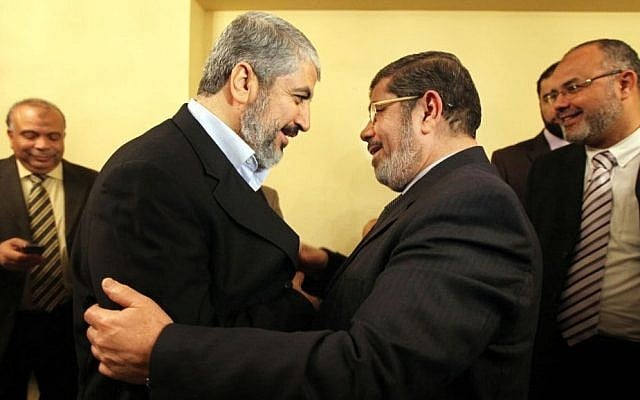 Hamas leader Khaled Mashal, left, congratulates Mohammed Morsi, the Muslim Brotherhood party's leader for winning the biggest number of seats in parliamentary elections in Cairo, January 21, 2012 (photo credit: AP)