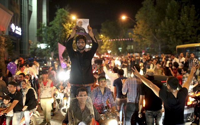 A supporter of Iranian presidential candidate Hasan Rowhani holds up his poster while celebrating Rowhani's victory, in Tehran, Iran, on Saturday, June 15, 2013. (photo credit: AP Photo/Ebrahim Noroozi) A supporter of Iranian presidential candidate Hasan Rowhani holds up his poster while celebrating Rowhani's victory, in Tehran, Iran, on Saturday, June 15, 2013. (photo credit: AP Photo/Ebrahim Noroozi)